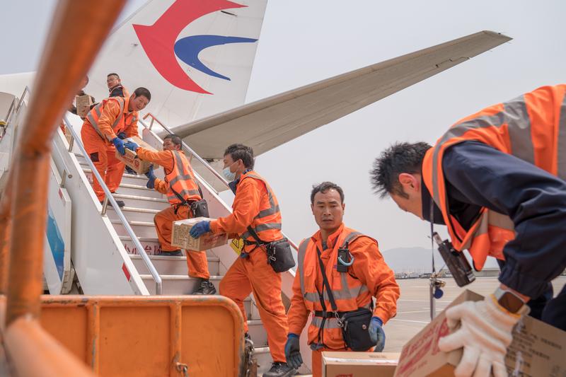 3月30日，在昆明长水国际机场，工作人员往飞机上搬运救援运往缅甸震区的物资。新华社